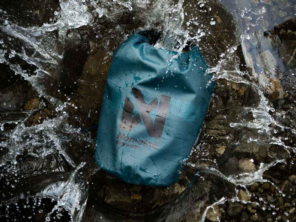 Non-stop Dogwear Multiuse Bag submerged in water, demonstrating its waterproof dry bag capabilities for rugged outdoor conditions.
