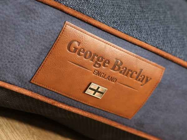 George Barclay Holbury Dog Sofa Bed - Moonlight Close-up of a George Barclay dog bed with a brown leather logo.