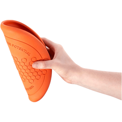Close-up of a hand holding the flexible orange Non-stop Dogwear Dog Flying Disc folded for packing