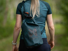 Woman carrying the Non-stop Dogwear Multiuse Bag on her back, highlighting its hands-free rope sling design for hiking or walking.