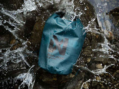 Non-stop Dogwear Multiuse Bag submerged in water, demonstrating its waterproof dry bag capabilities for rugged outdoor conditions.