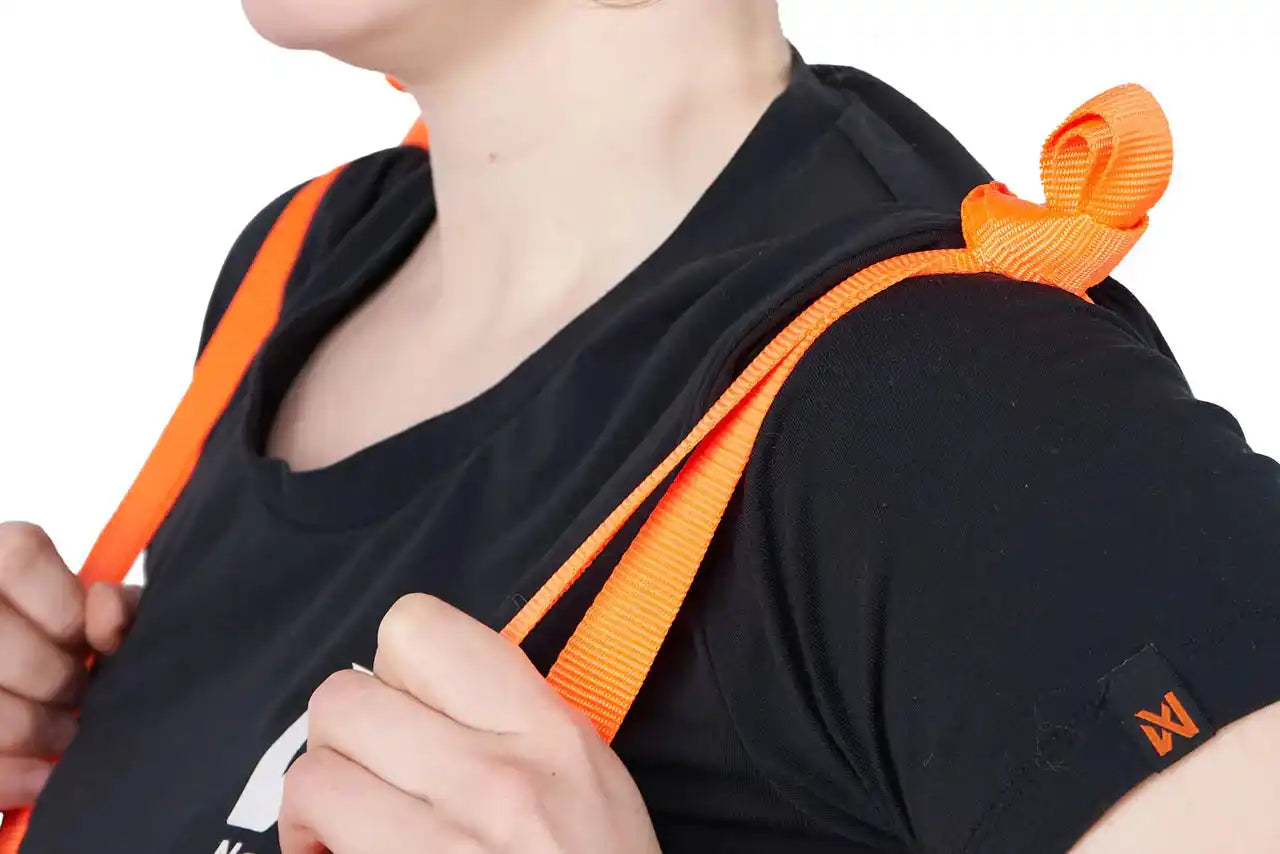 Person wearing a black shirt with an orange strap Dog Rescue Sling