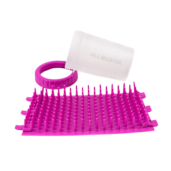 Disassembled Dexas Mudbuster in pink showing silicone bristles, lid, and container, ideal for cleaning muddy dog paws on-the-go.
